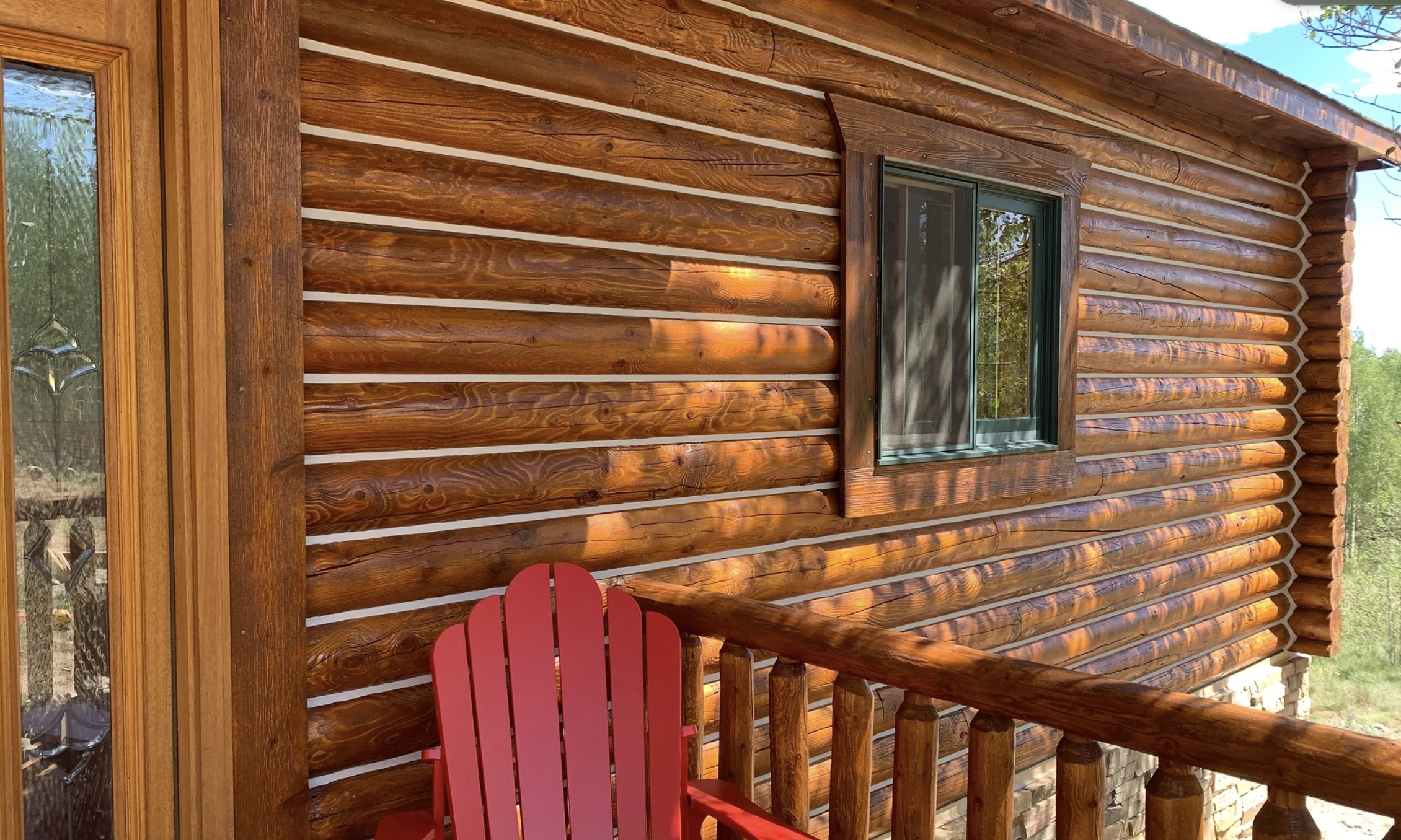 Professional log home chinking showing beautifully finished log exterior with white chinking