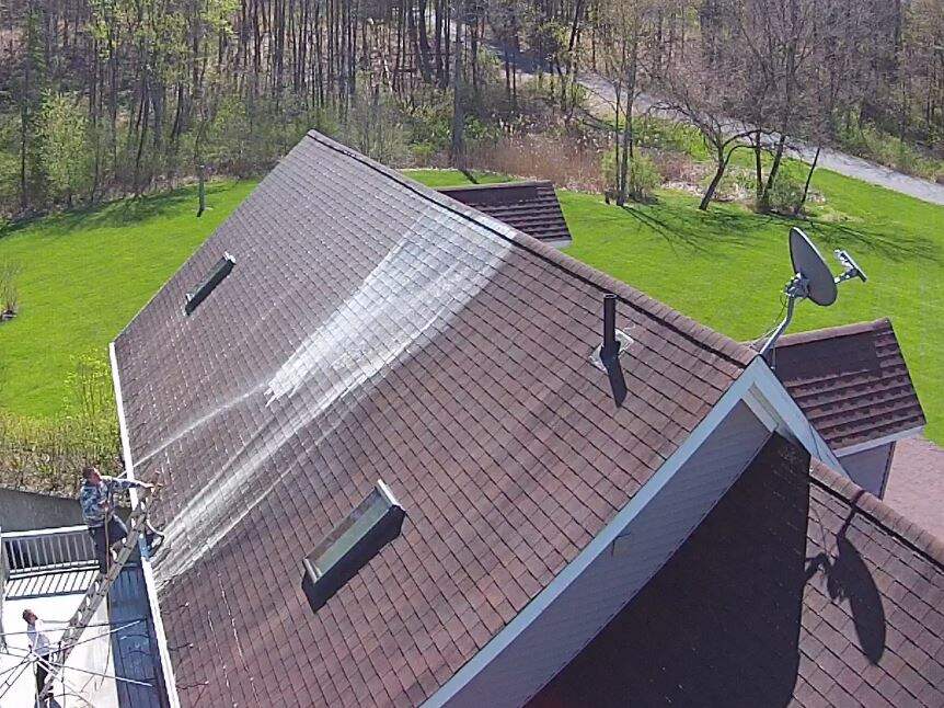Aerial view of house roof showing brown shingles that would benefit from soft washing treatment